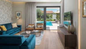 A modern living room with a blue sofa, a coffee table, and a TV on a wooden stand.