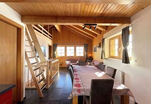 Enjoy meals with family and friends at this spacious dining area, featuring a long table and comfortable seating for many.