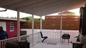A covered patio area with tiled flooring, a grill, and outdoor seating. - Forget your worries in this serene space. Pool view, top floor. Privacy gate. (Blue Hills)