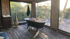 Ein Badezimmer mit freistehender Badewanne, Waschbecken und Waschtisch.