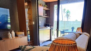 A modern living room with a sofa, a decorative lamp, and a starfish on a side table. - Flat I 002 Villas Manatee Patacho - AL (Porto de Pedras)