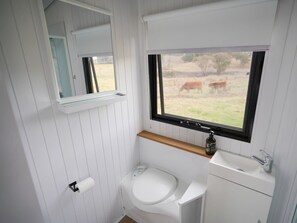 Un baño pequeño con inodoro, lavabo y ventana.