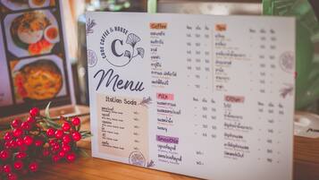 Un panneau affichant le menu, avec une liste de sodas italiens, de cafés, de laits et de smoothies.