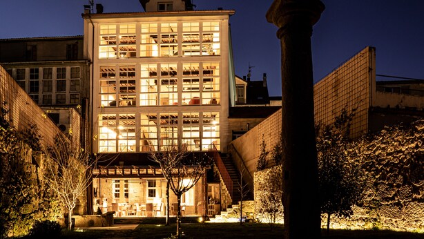 A multi-story building with large windows and a staircase leading to the upper floor. - Acouga Hotel Boutique (Celanova)