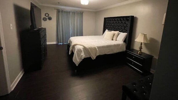 Een hotelkamer met een bed, een dressoir, een lamp en een televisie.