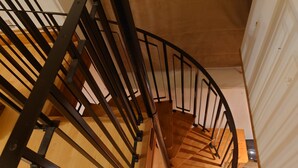 A spiral staircase with black railings and wooden steps. - Fully Detached Cottage House Loddington Kettering (Kettering)