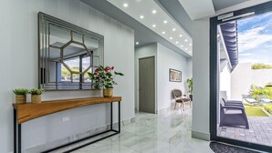 Een modern interieur met een console tafel, een grote spiegel en een potplant.