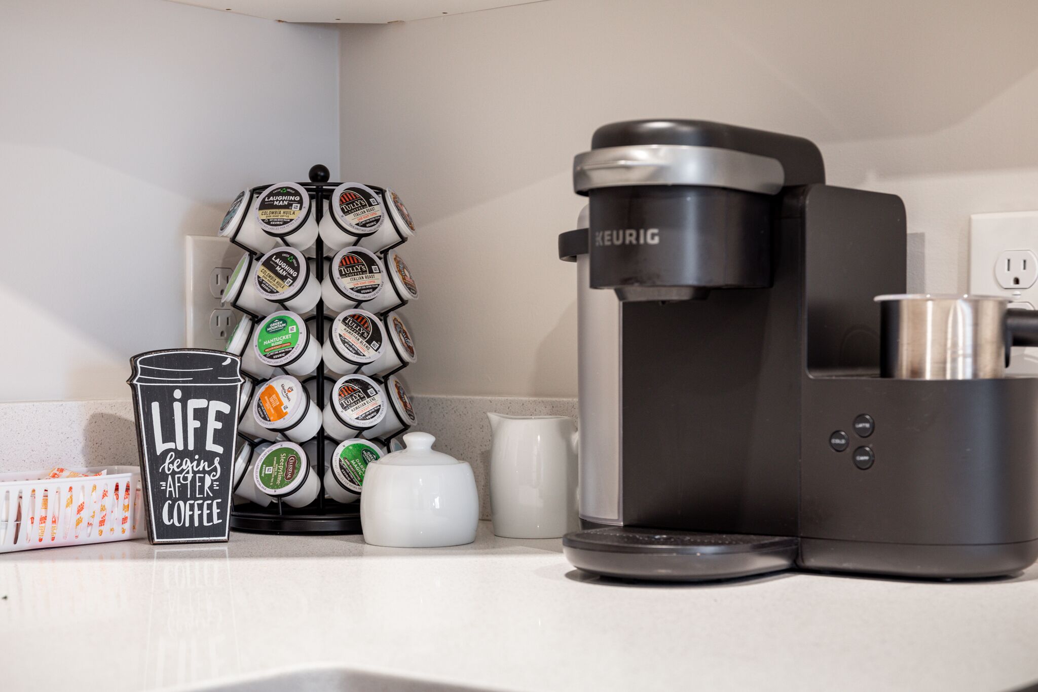 A coffee maker, a coffee pod holder, a coffee pot, and a mug on a kitchen counter.