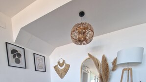 Una sala moderna con un sofá gris, una mesa de centro de madera y una lámpara colgante.