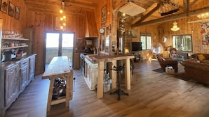 A cozy wooden cabin interior with a dining area, kitchen, and seating space. - Atypical villa "Cabane Oléron" with heated swimming pool (Saint-Trojan-les-Bains)