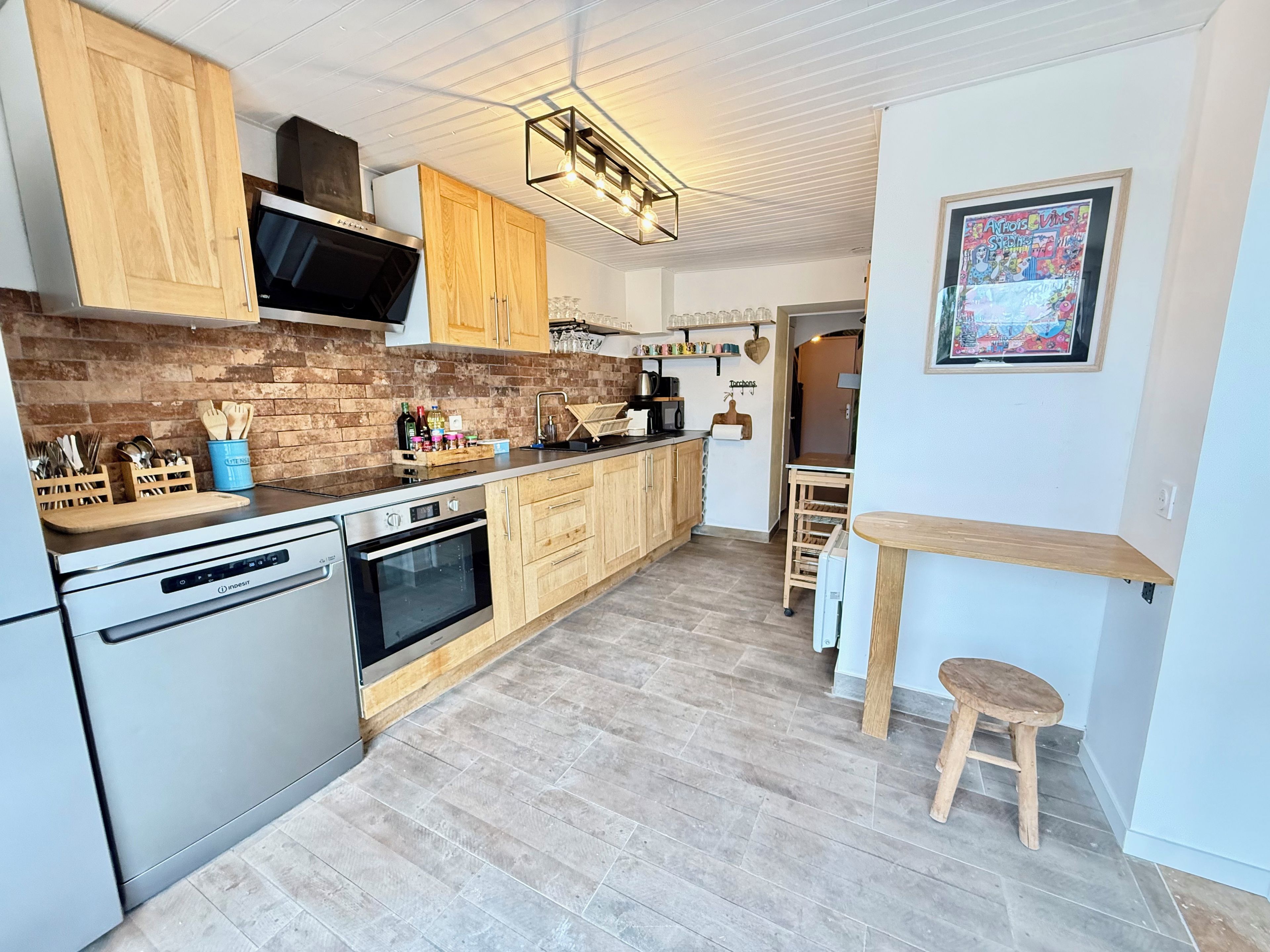 A modern kitchen with wooden cabinets, stainless steel appliances, and a brick backsplash.