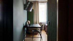 Un comedor con una mesa, sillas y un televisor de pantalla plana montado en la pared.
