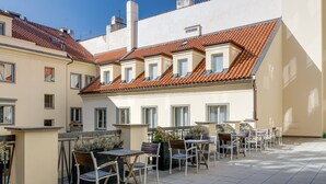 Una terraza con mobiliario exterior y vistas a edificios cercanos.