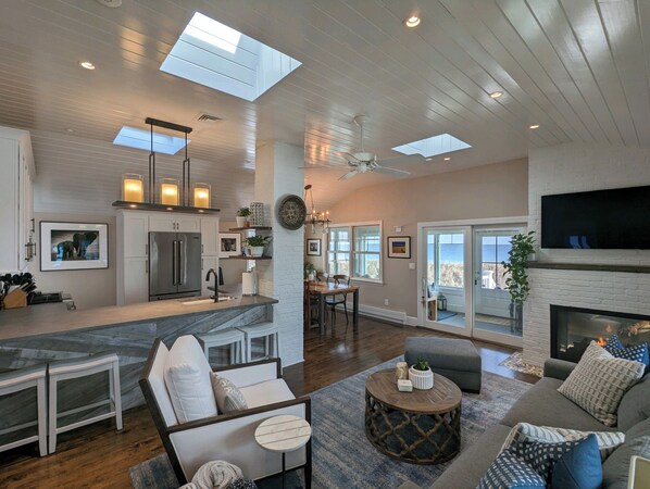 A spacious living area with a fireplace, a dining area, and a kitchen with a large island.