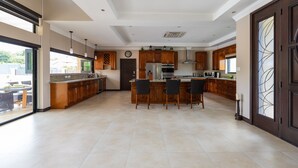Cozinha ampla com ilha central, armários de madeira e uma grande janela.
