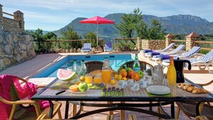 A poolside breakfast setup with a table, chairs, and a view of mountains. - Casa Irene - Four Bedroom Villa, Sleeps 7 (El Gastor)