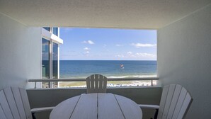 A balcony with a view of the ocean, a round table, and two white chairs. - The 9th Floor Offers A True Blue View Of The Sparkling Gulf Of Mexico! (pensacola)