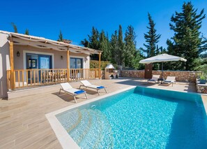 Ein Poolbereich mit Liegestühlen und einem Gebäude mit Balkon.