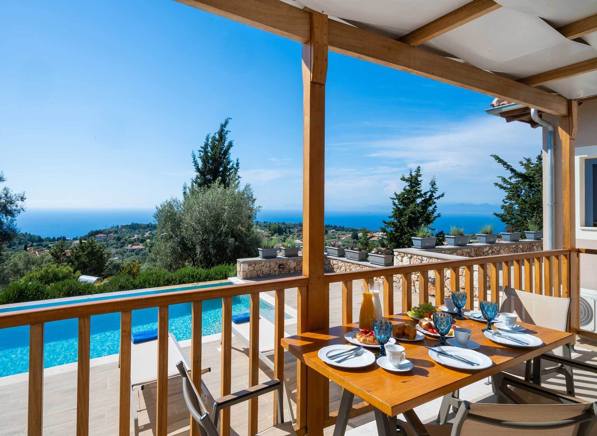 A dining area with a view of the sea, a pool, and outdoor furniture.