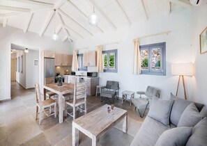 Un interior moderno con comedor, cocina y zona de estar.