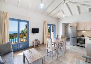 A spacious living area with a view of a pool, a dining table with chairs, a sofa, and a kitchen area with modern appliances.