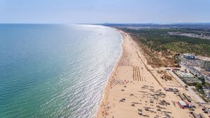 An aerial view of a beach with a long stretch of sand, a few buildings, and a clear sky. - Casa Branca - Four Bedroom Villa, Sleeps 8 (Altura)