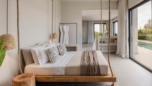 Un dormitorio moderno con una cama colgante, vistas al exterior y una piscina.
