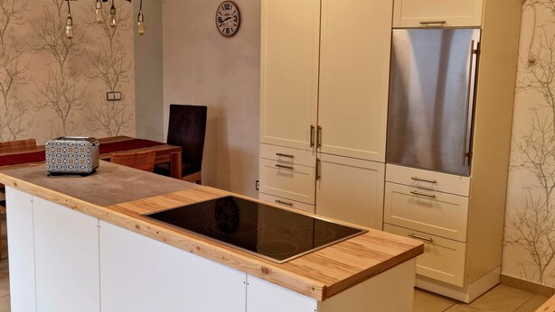 A modern kitchen with a central island, stainless steel appliances, and a decorative light fixture. - Relaxation oasis in the heart of Rheinhessen, Haus Weinbergsblick (Armsheim)
