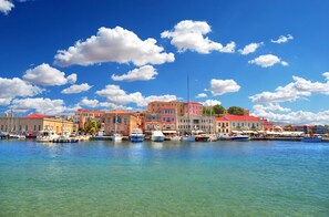 Enjoy the serene waterfront atmosphere with calm waters reflecting the colorful buildings and boats.
