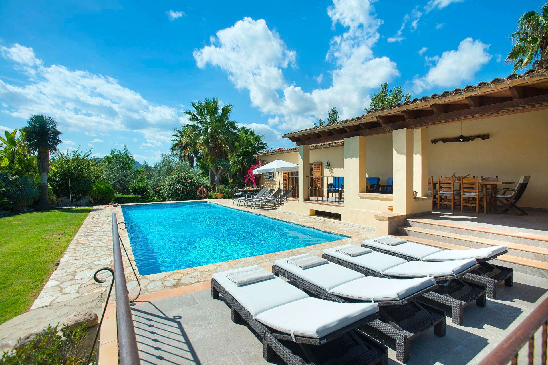 A swimming pool with lounge chairs and a patio area.