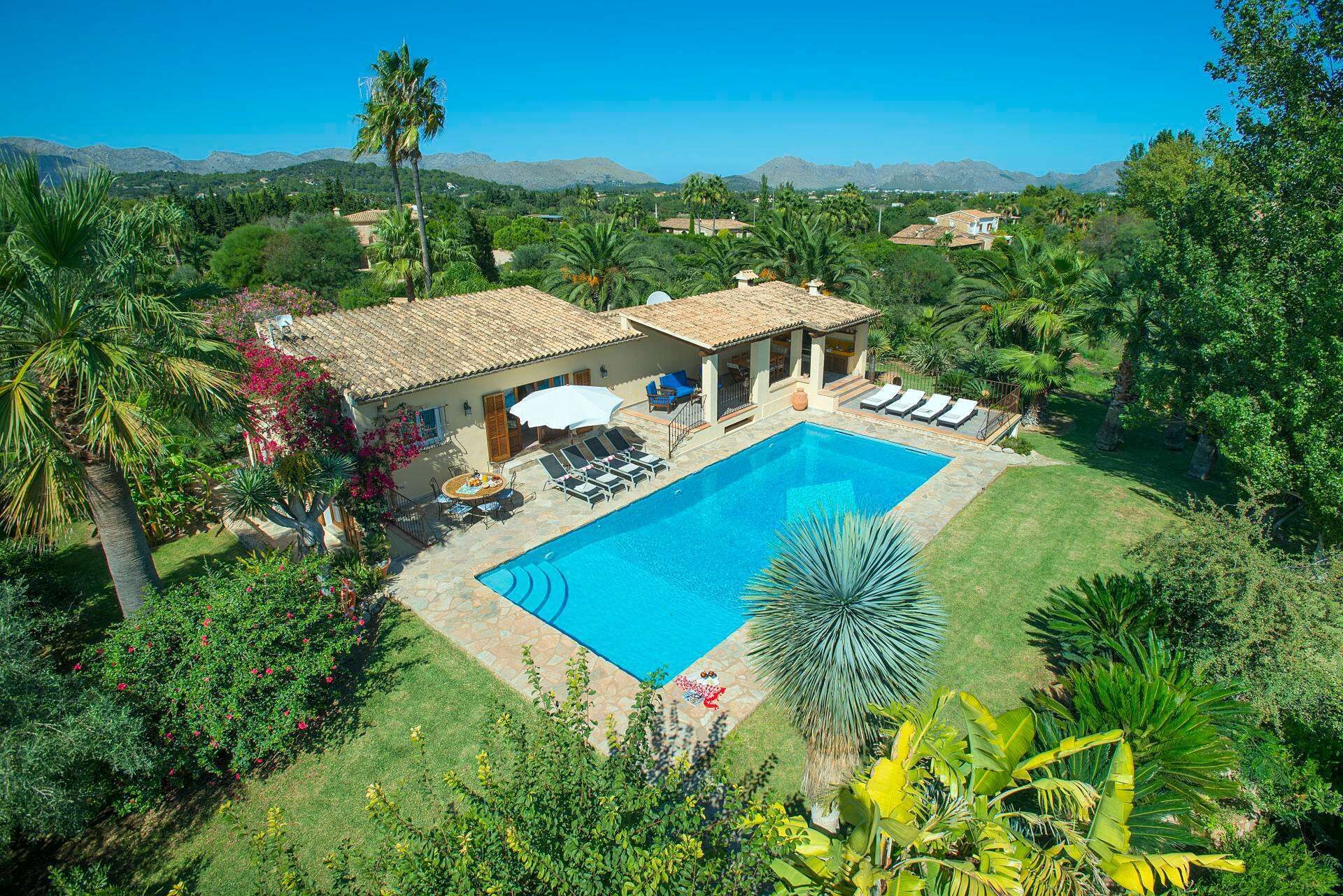 Area piscina con vista diretta su una piscina, sdraio e patio con tavolo e sedie.