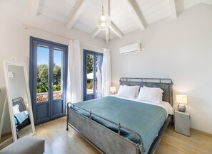 Un dormitorio con cama, mesita de noche, espejo y ventilador de techo.