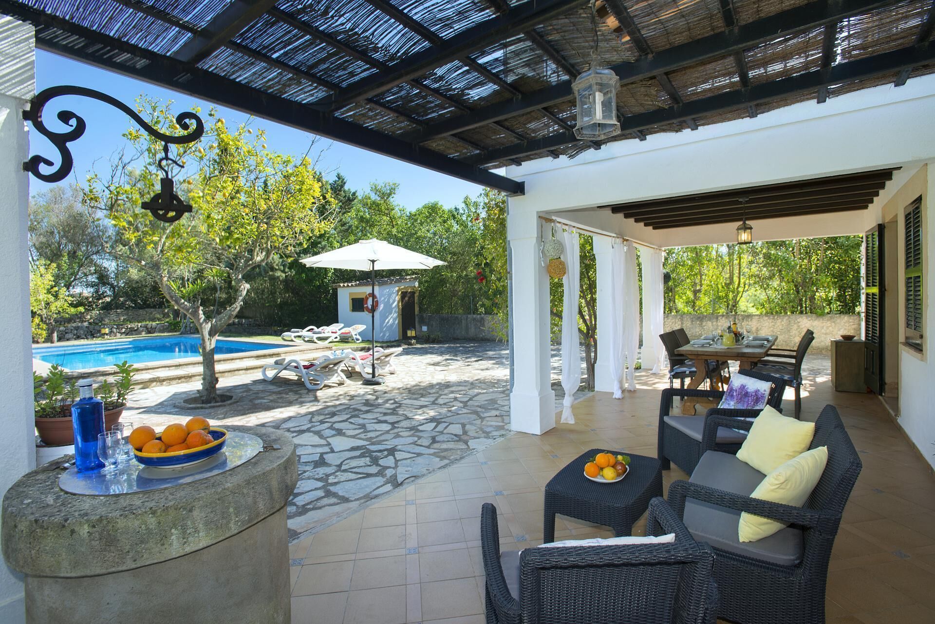 An outdoor patio area with a pool, lounge chairs, and a dining table.