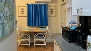 A compact kitchen with a dining area, a microwave, and a coffee maker.