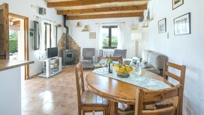 Un salon confortable avec une cheminée, une table à manger avec des chaises et un téléviseur.