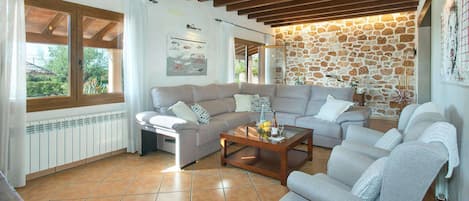 A living room with two sofas, a coffee table, and a stone wall.