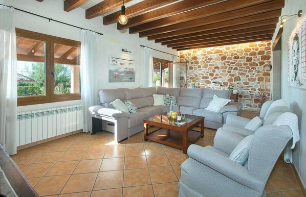 A living room with two sofas, a coffee table, and a stone wall.