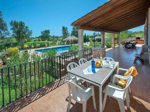 Eine Terrasse mit Pool, Sitzgelegenheiten im Freien und Blick auf die Landschaft.