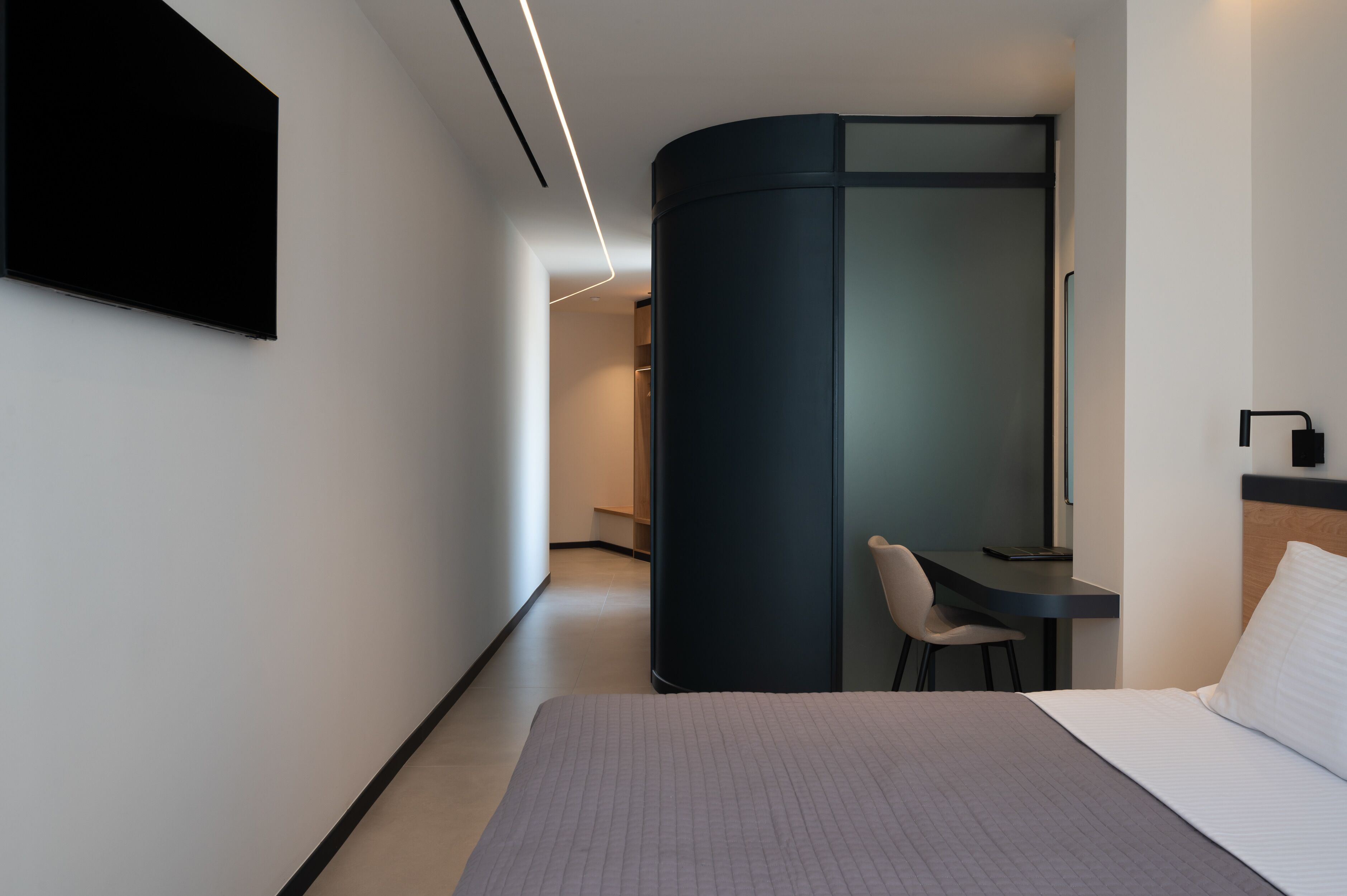 Una habitación de hotel moderna con una cama, un escritorio y una silla.