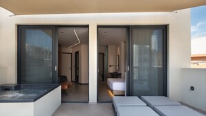 A modern hotel room with a glass door leading to a balcony, a small seating area, and a bed. - Nema Hotel Athens (Athens)