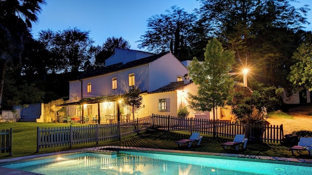 A two-story house with a swimming pool, surrounded by a wooden fence and trees. - El Molino del Pilón - Five Bedroom Villa, Sleeps 10 (Arcos de la Frontera)