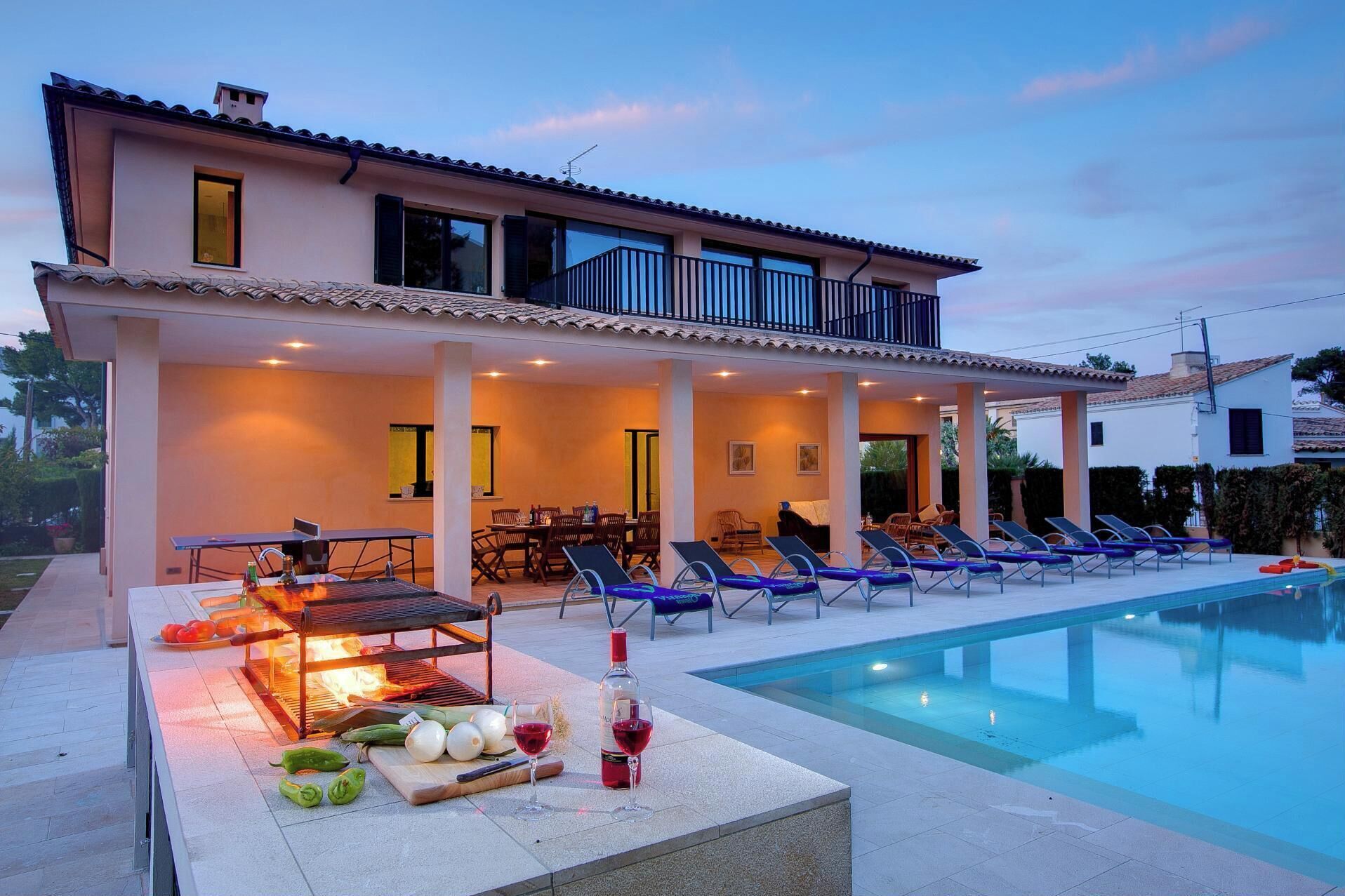 Une villa moderne dotée d’une piscine, d’un espace salon extérieur et d’un coin barbecue.