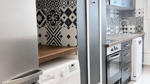 A modern kitchen with a built-in washing machine, a microwave, and a dishwasher.