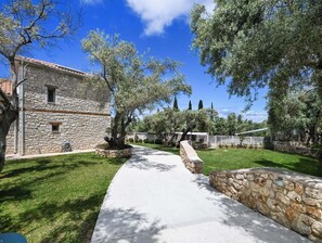 Un edificio de piedra con un camino empedrado que lleva a una zona ajardinada.