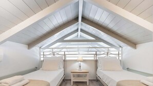 A room with a sloped ceiling, two beds, a nightstand, and a lamp. - Mirto - Three Bedroom Villa, Sleeps 6 (Tsoukalades)