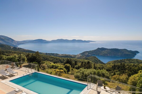 Una piscina con vistas al mar y colinas.