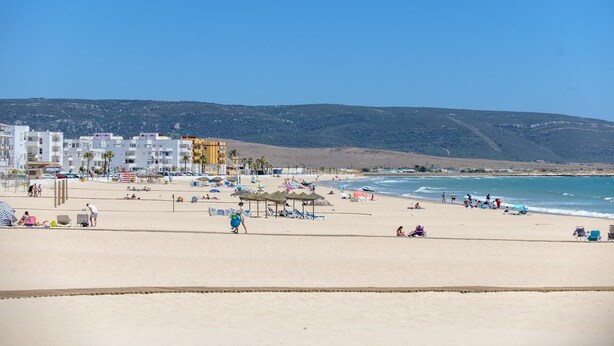 A beach with buildings in the background, clear skies, and people enjoying the beach. - Casa Bellota - One Bedroom Villa, Sleeps 2 (Vejer de la Frontera)