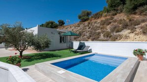 A swimming pool with a sun lounger and a small building with a green roof. - Casa Bellota - One Bedroom Villa, Sleeps 2 (Vejer de la Frontera)