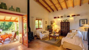 A cozy living room with a fireplace, a television, and comfortable seating. - Ca'n Paner - One Bedroom Villa, Sleeps 2 (Mallorca)