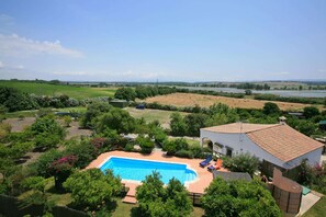A residential property with a swimming pool, surrounded by lush greenery and a view of a river. - Casa de la Fuente - Two Bedroom Villa, Sleeps 4 (Vejer de la Frontera)